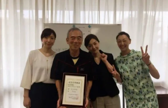 表彰状を手に記念撮影する4人
