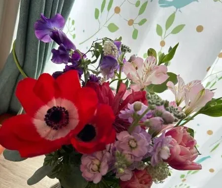 テーブルに飾られた花瓶いっぱいの色とりどりの花束