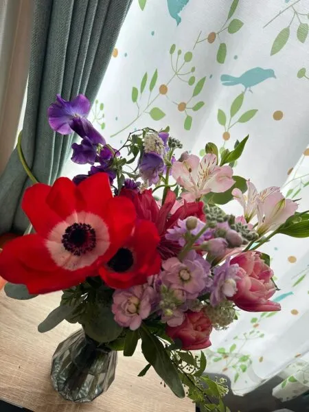 テーブルに飾られた花瓶いっぱいの色とりどりの花束