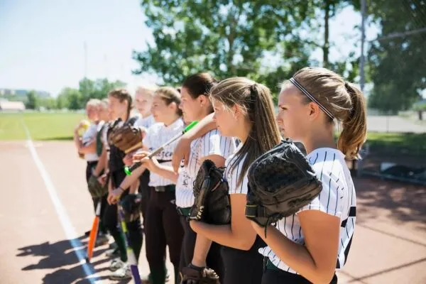 グローブを持って一列に並ぶ女子ソフトボールチームの選手たち