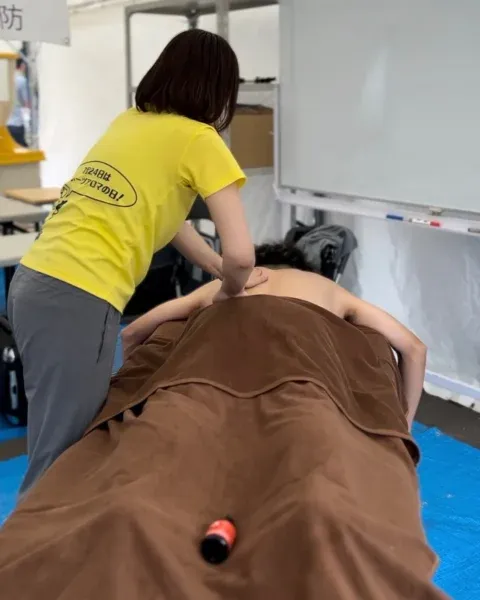 テント内で選手の背中をケアするスポーツアロマトレーナー