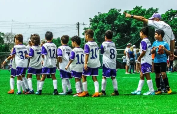 サッカーの練習前にコーチの話を聞く少年たちのチーム