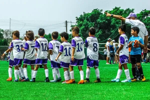 サッカーの練習前にコーチの話を聞く少年たちのチーム
