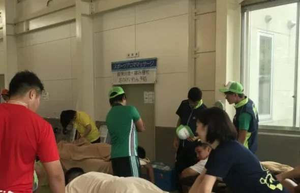 体育館で選手にスポーツアロママッサージを行う様子