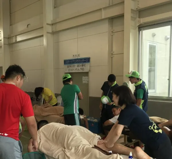 体育館で選手にスポーツアロママッサージを行う様子
