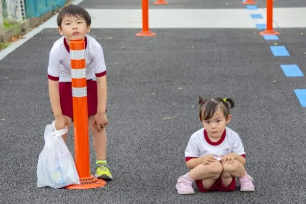 道路脇に立つ制服姿の男の子と女の子
