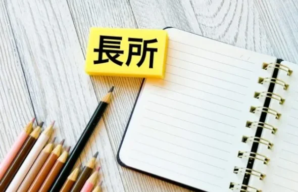 「長所」と書かれたブロックとノート、色鉛筆