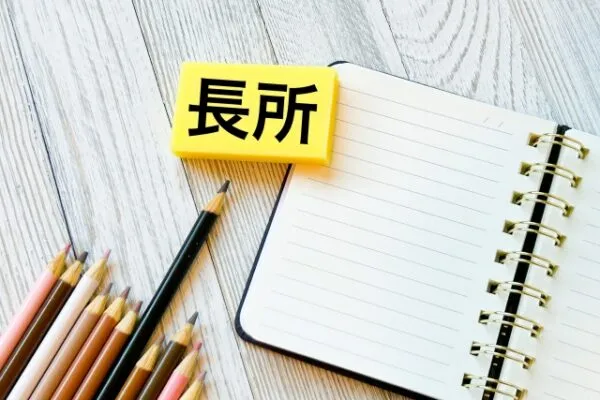 「長所」と書かれたブロックとノート、色鉛筆