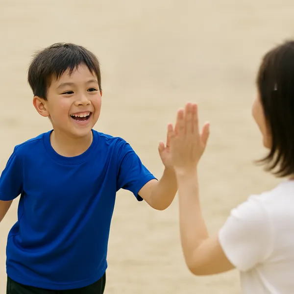 砂浜でハイタッチをする男の子と母親