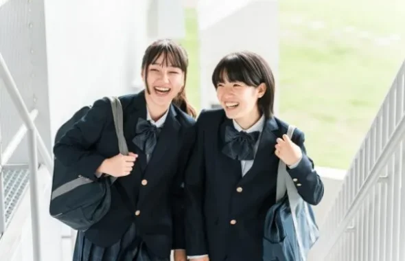 階段を並んで歩く笑顔の女子学生2人