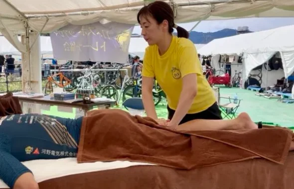 テント内で選手の脚をケアするスタッフ