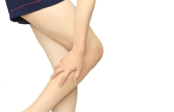 制服姿でふくらはぎを押さえる女子学生の脚
