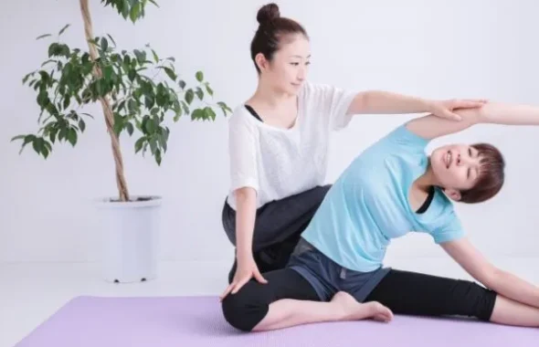 ストレッチをサポートする女性と子ども