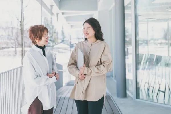 資料を持って会話する女性2人