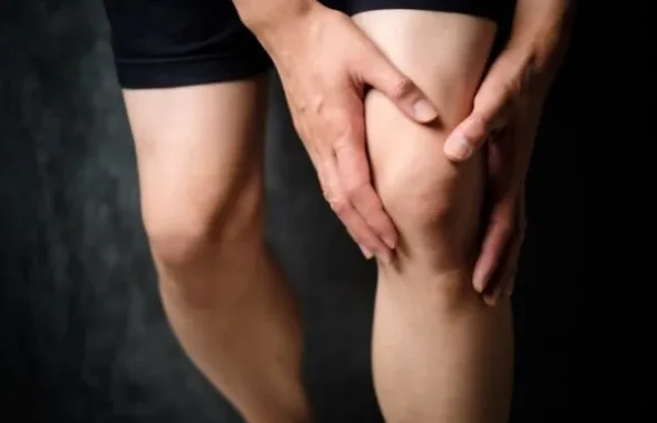 膝を両手で押さえる人の脚