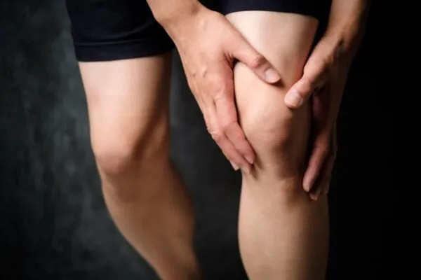 膝を両手で押さえる人の脚