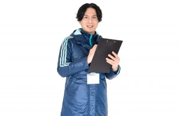 クリップボードを持つ指導者風の男性