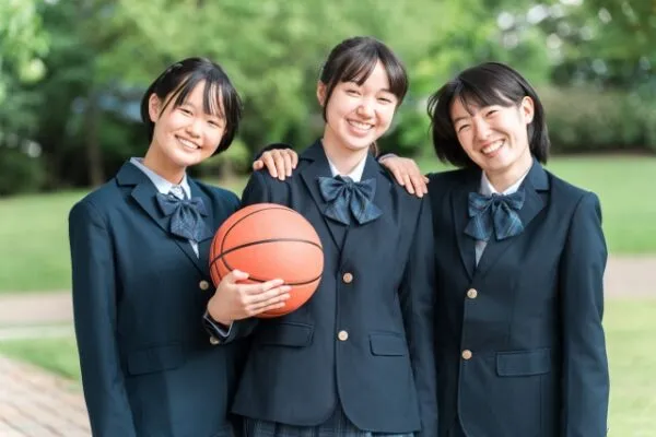 バスケットボールを持つ制服姿の女子高生3人