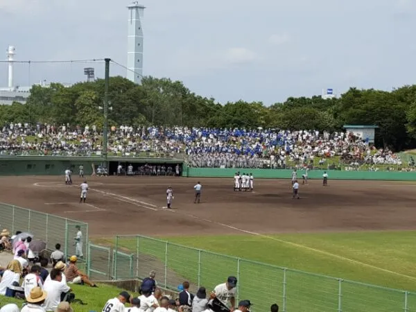 満員の観客席で行われる高校野球の試合