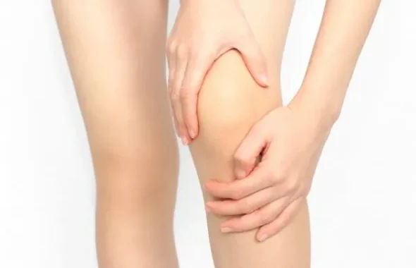 両手で膝を押さえる人の脚