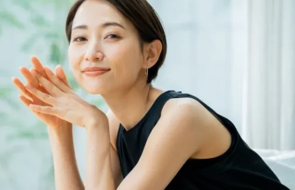 手を頬に添えて微笑む女性