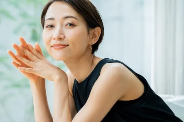 手を頬に添えて微笑む女性