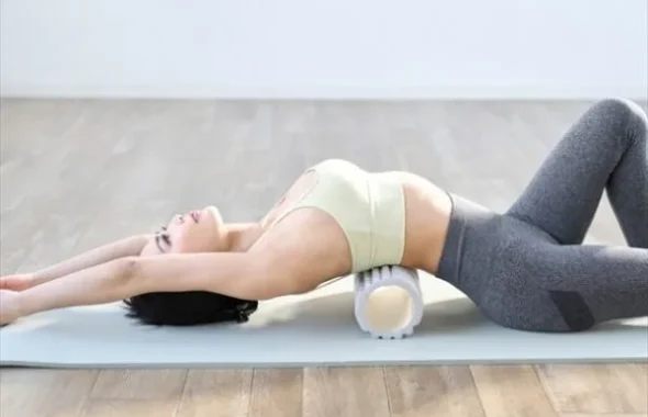 フォームローラーを使ってストレッチをする女性
