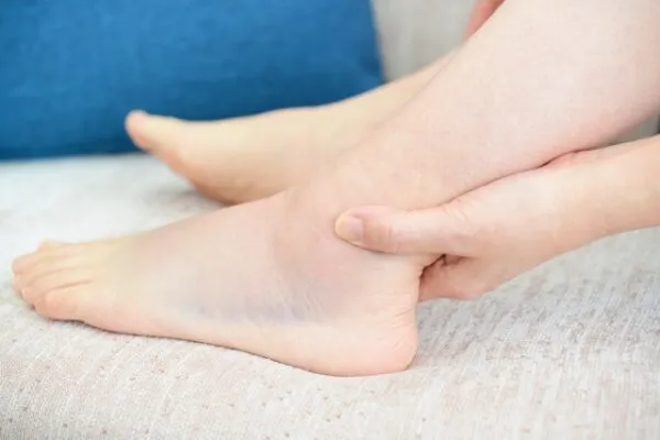 足首を手で押さえる人の脚