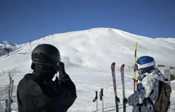 雪山でスキー用具を持つ2人の後ろ姿