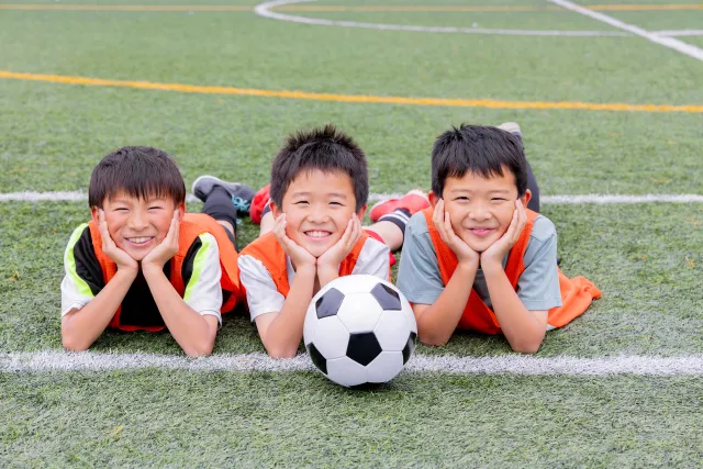 サッカー仲間で笑って寝転んでいる